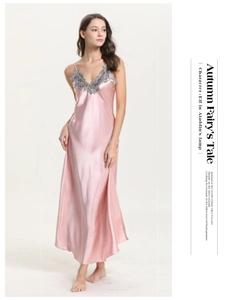 Détail d'une nuisette en satin rose avec dentelle grise délicate et décolleté en V