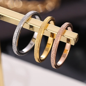 Set of three frosted minimalist 18K gold rings in silver, gold, and rose gold finishes