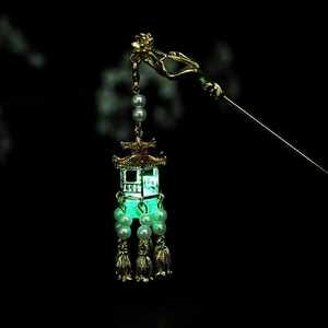 Macro view of glowing vintage pavilion hair stick with white pearls and green LED light