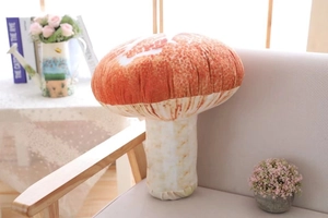 Realistic mushroom plush pillow featuring a spotted red cap on a soft grey sofa