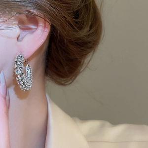 Close-up of sparkling silver rhinestone hoop earrings worn by a model for elegant style