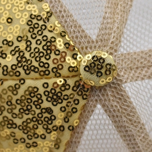 Détail de paillettes dorées et de tissu en maille sur un chapeau de soleil jaune