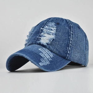 Detail view of distressed navy denim baseball cap with vintage frayed holes and texture