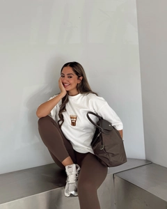 Détail du t-shirt blanc en coton avec imprimé et legging de yoga marron pour femmes