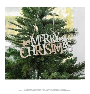 Detail of wooden Merry Christmas hanging ornament with star accents on a tree