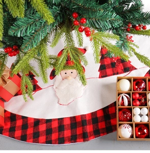 Detail of Christmas tree skirt with classic red black plaid edge and Santa Claus pattern