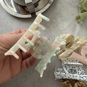 Detail of colorful acetate hair claw clips with marble textures and metal spring