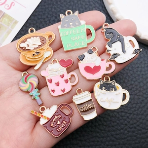 Detail of colorful enamel cat and coffee cup pendants on hand with black leather background