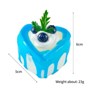 Realistic heart-shaped blue cake model with faux blueberries and green leaf decoration