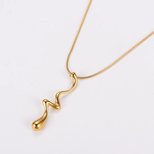 Minimalist gold wavy pendant necklace featuring a polished flowing metal finish on white