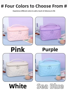Detailed view of four colors heart-quilted travel toiletry bags with top handles