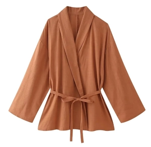 Detail view of caramel wrap top featuring a V-neckline and adjustable waist tie belt