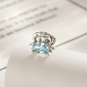 Cute titanium steel crab cartilage earring with blue gemstone in a macro studio shot