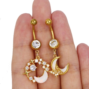 Makroansicht goldener Bauchnabelpiercings mit Mond, Schmetterling und Zirkonia-Details