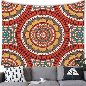 Detailed Bohemian mandala tapestry in orange and teal hues above a cozy living room sofa