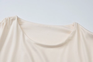 Détail du col rond et de la maille fine de ce haut beige ajusté à manches longues