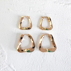 Macro detail of geometric twisted triangle gold earrings in small and large sizes