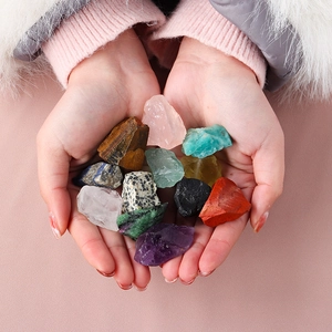Natural healing crystal set with amethyst and rose quartz held in hands on pink background