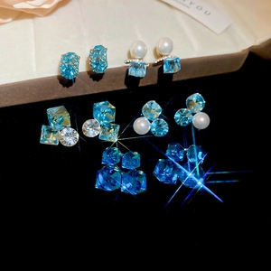 Detailed set of 18k gold plated earrings featuring green zircons and elegant pearls