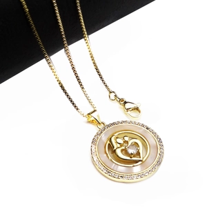 Close-up of heart-shaped MOM necklace pendant with zircon pavé and white pearl shell inlay