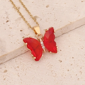 Elegant gold chain necklace with a translucent red butterfly pendant and tiny cubic zirconia