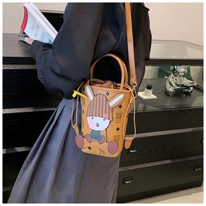 Detail of a brown bucket bag with rabbit charm and retro monogram pattern