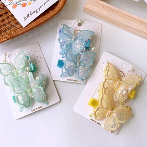 Dettaglio di fermagli per capelli a farfalla in tulle con paillettes e perle multicolori