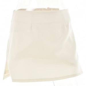 Detail of a beige mini skirt with waist darts and a subtle side slit on white background