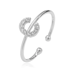 Detail of silver-colored open ring with cubic zirconia letter C and polished bead end