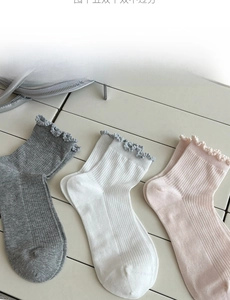 Detailed view of frilly lettuce edge socks in grey, white and pink ribbed cotton knit