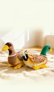 Close-up of realistic plush mallard and duck toys on a soft sunlit indoor carpet