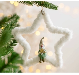 Close-up of white plush star Christmas ornament featuring a forest gnome on pine branch