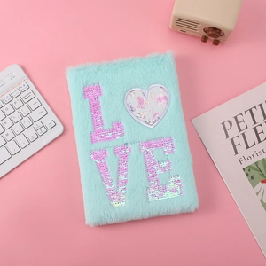 Macro detail of mint green plush notebook with pink sequin LOVE text on pink background