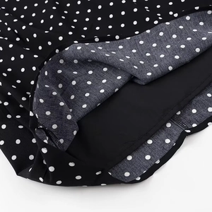 Detailed close-up of polka dot dress hem with high-quality black lining and chiffon fabric
