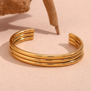 Macro shot of polished triple-layered 18K gold-plated stainless steel open cuff bracelet
