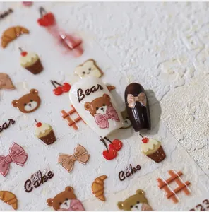 Macro detail of 3D embossed bear and pastry nail stickers with textured creamy finish