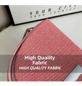 Detail showing red and white twill fabric texture with pink leather trim and metal clasp