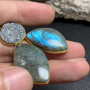 Macro shot of three-stone labradortite and druzy pendant with gold-plated edges