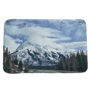 Absorbent flannel floor mat featuring a snowy mountain forest and road landscape