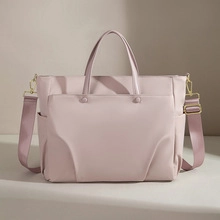 Pink fabric Boston bag featuring gold hardware and multiple storage pockets