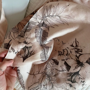 Macro shot of tropical leaf prints on textured linen fabric of the pink shoulder bag