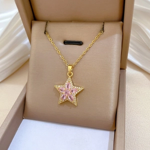 Détail du collier étoile rose serti de zircons dans son coffret à bijoux beige raffiné