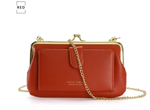Detail of red PU leather shoulder bag with gold chain strap and metal clasp closure