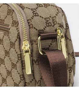 Detailed close-up of brown monogram canvas texture with golden zipper and D-ring hardware