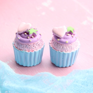Detail shot of miniature resin cupcakes with blue base, purple icing and pink hearts
