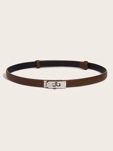 Detail of a brown leather thin belt featuring a polished silver metal twist lock buckle