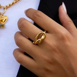 Minimalist 18K gold plated knot ring with high polish finish shown on model finger