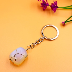 Macro view of opal-like natural stone wrapped in silver wire on a keyring