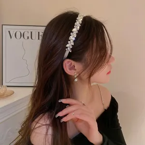 Elegant crystal headband with marquise rhinestones and matching pearl earrings on a model