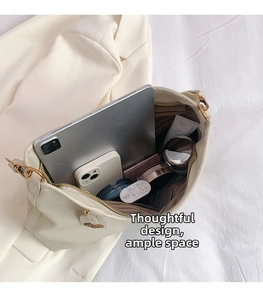 Detail shot showing the large capacity of the cream tote bag holding a tablet and cosmetics
